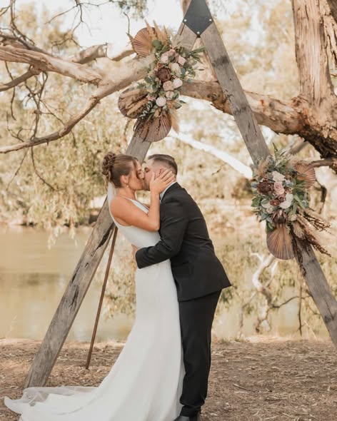 Couple kissing under a floral arbour